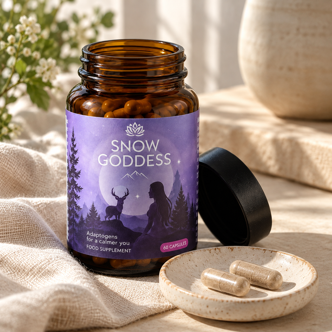 Snow Goddess open amber glass supplement bottle with two capsules on a ceramic dish